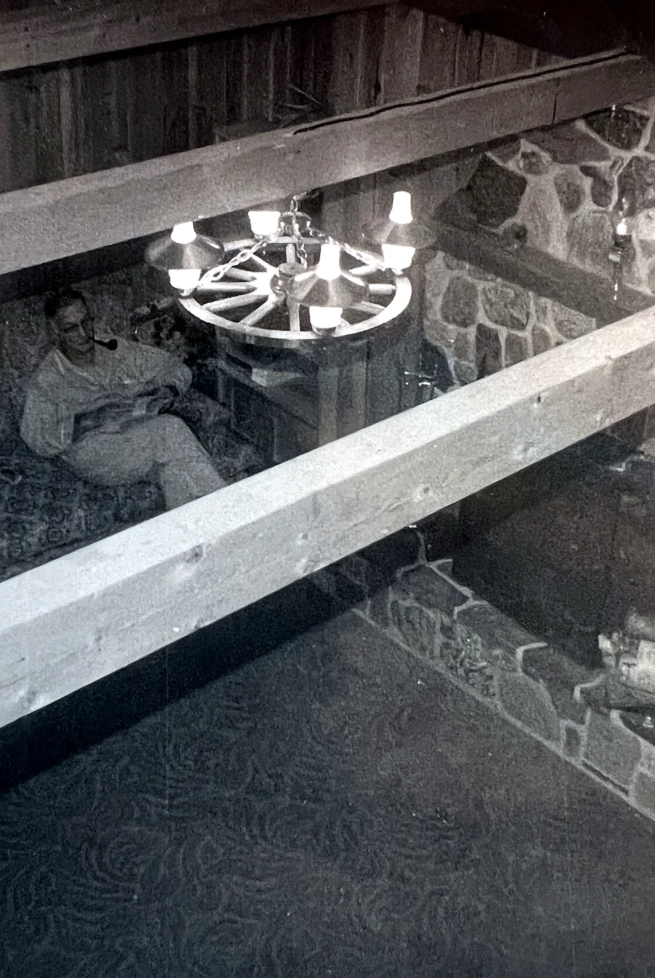 Fred Logan Bull reading in the living room with his pipe — every memory of him comes with that pipe. Taken from the loft.